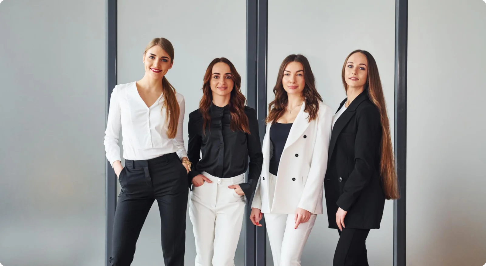 Four women in business attire posing